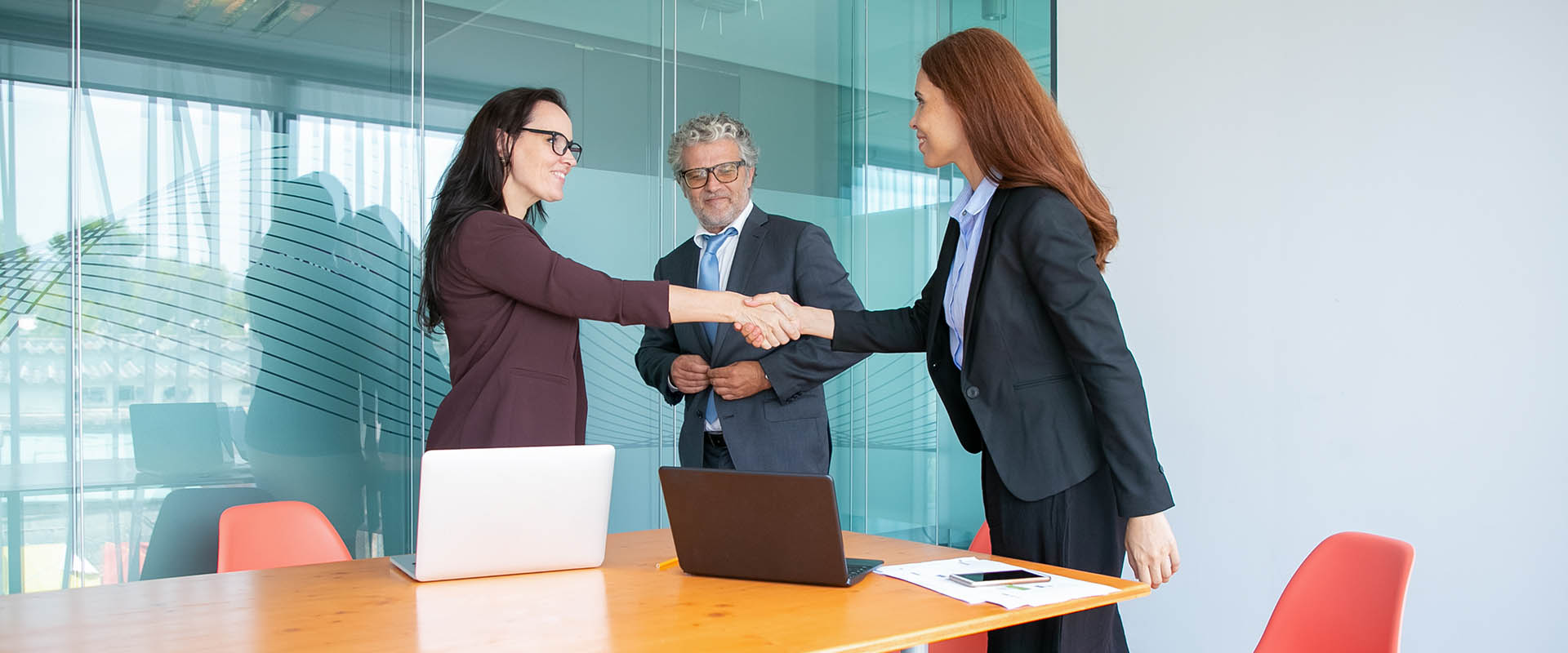 Confident businesswomen handshaking and greeting